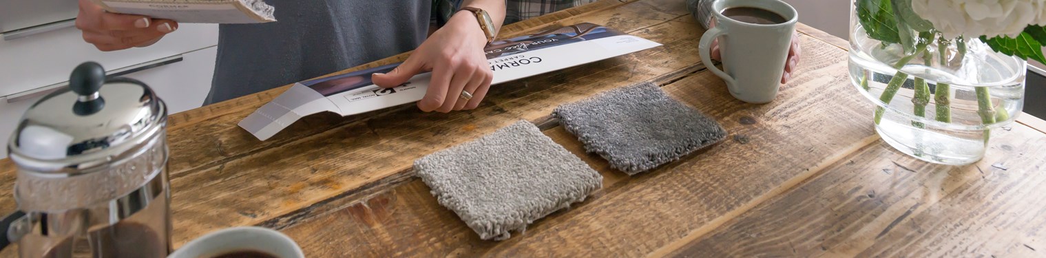 A couple view three carpet samples received from Cormar Carpets
