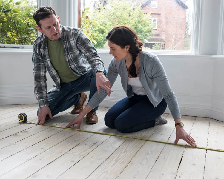 Julia and Mark measure their room ready for new carpet